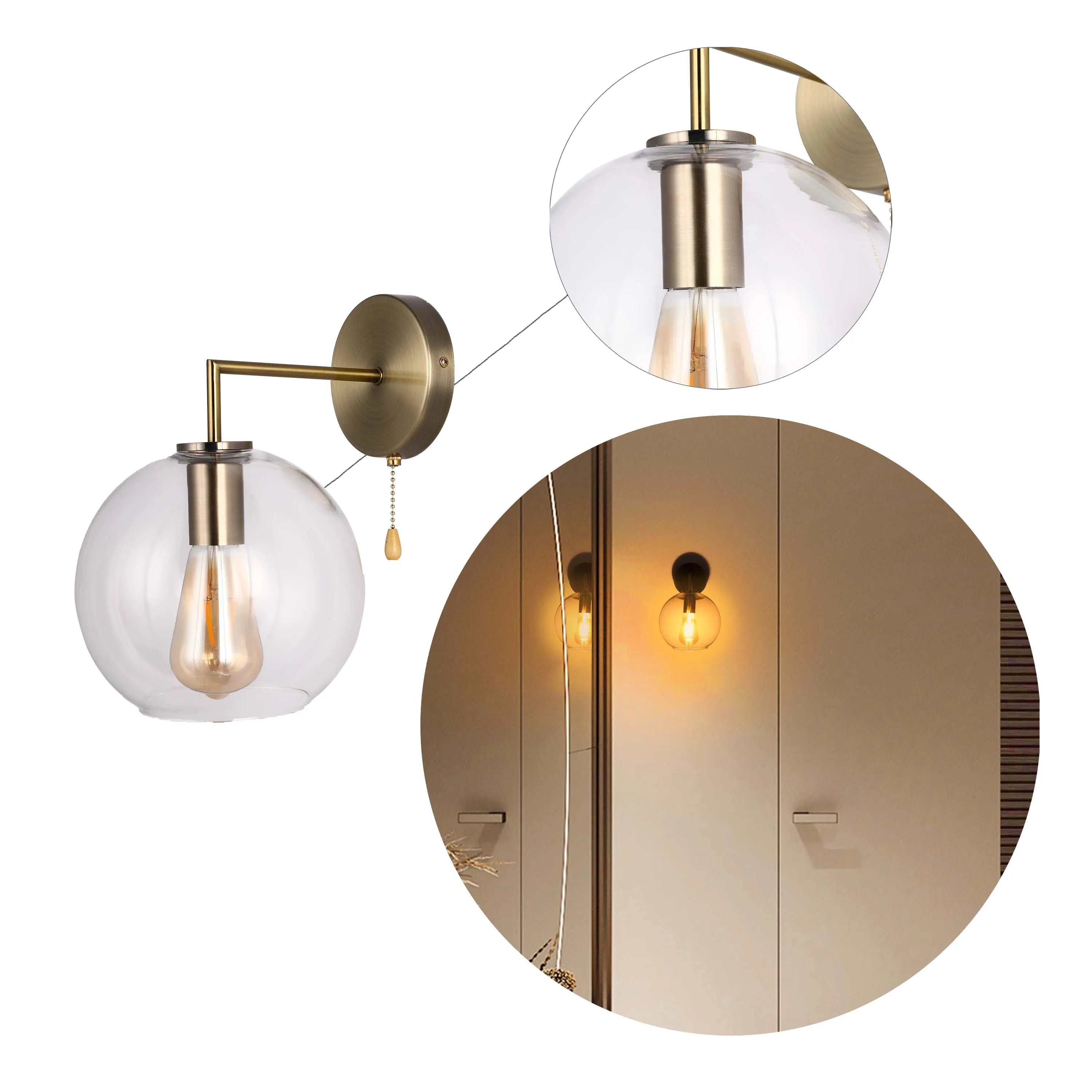 Elegant wall light featuring a clear glass globe shade and antique brass finish, casting a warm glow.