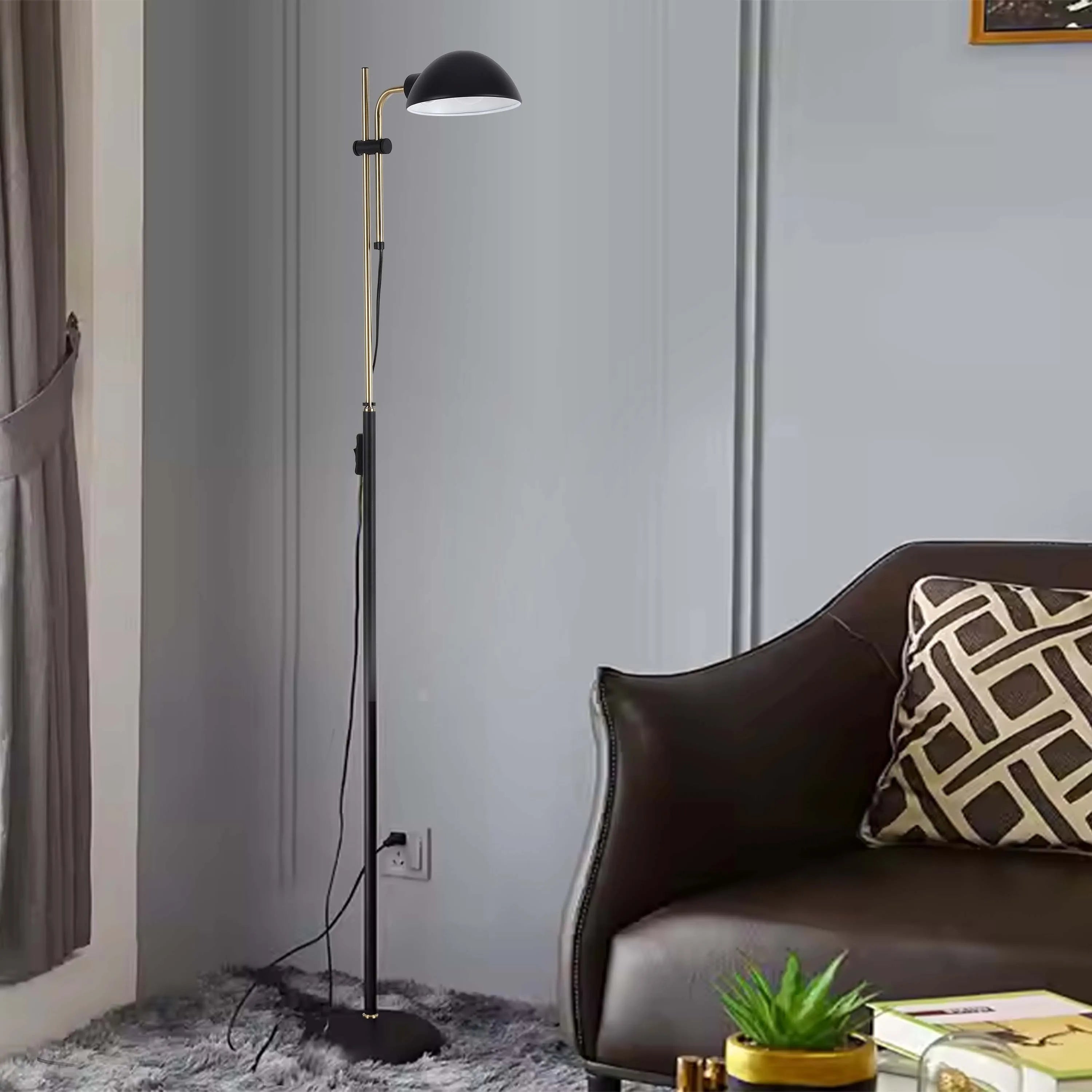 A black and gold adjustable floor lamp, beside a chair in a cosy living room. A decorative yet functional piece of lighting.
