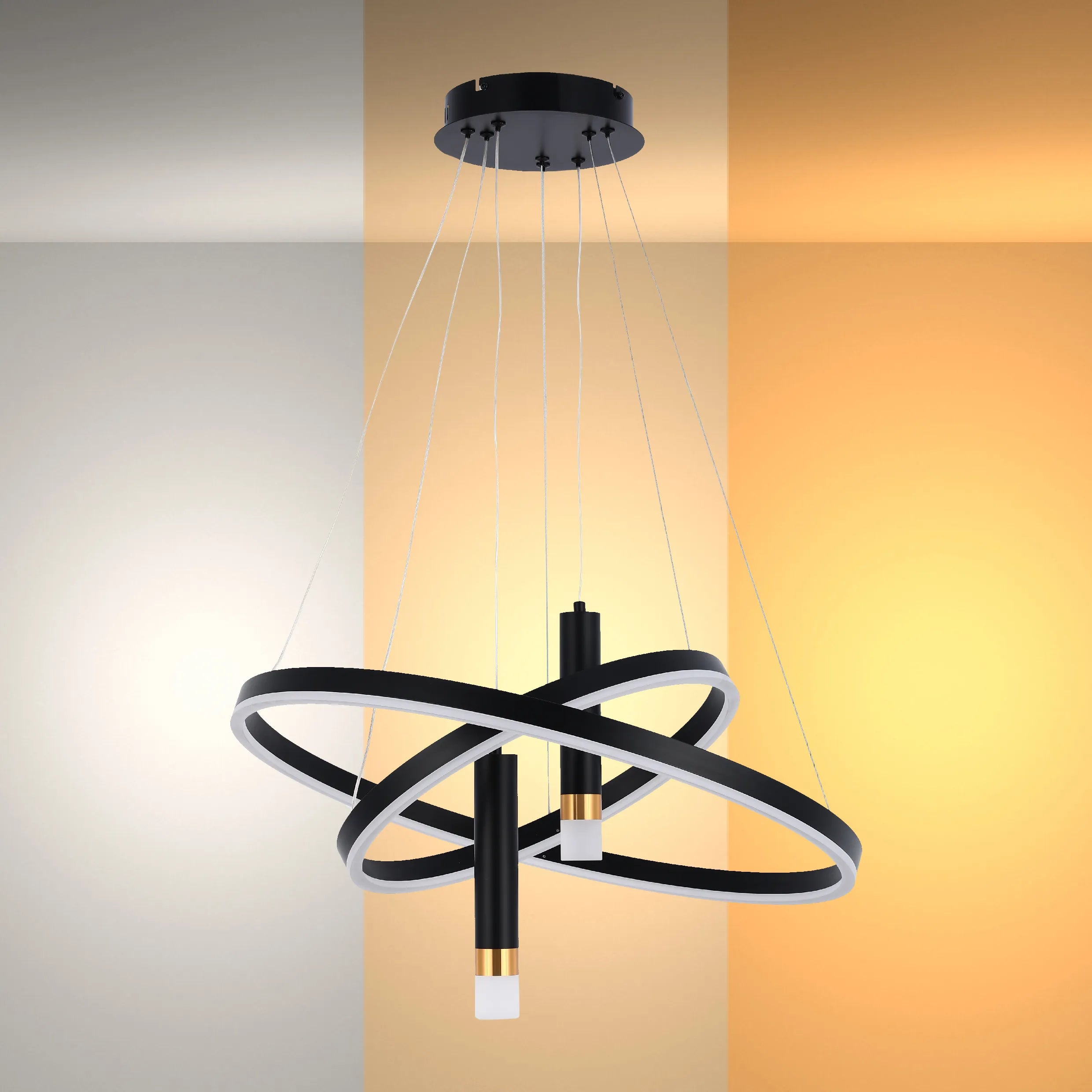 A modern chandelier with black rings and white LED strips, suspended by thin wires. The backdrop features warm and cool tones.
