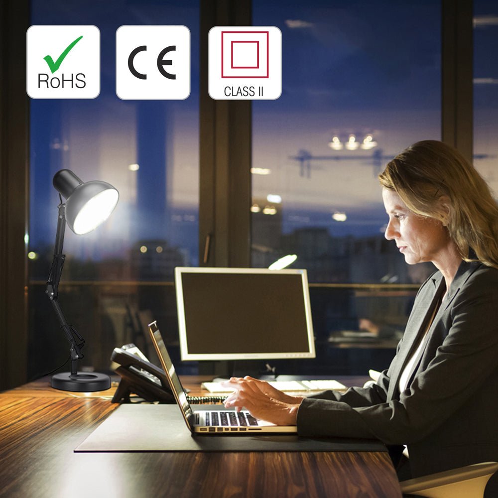 A desk with a lamp, laptop, monitor and phone, providing an office workspace.