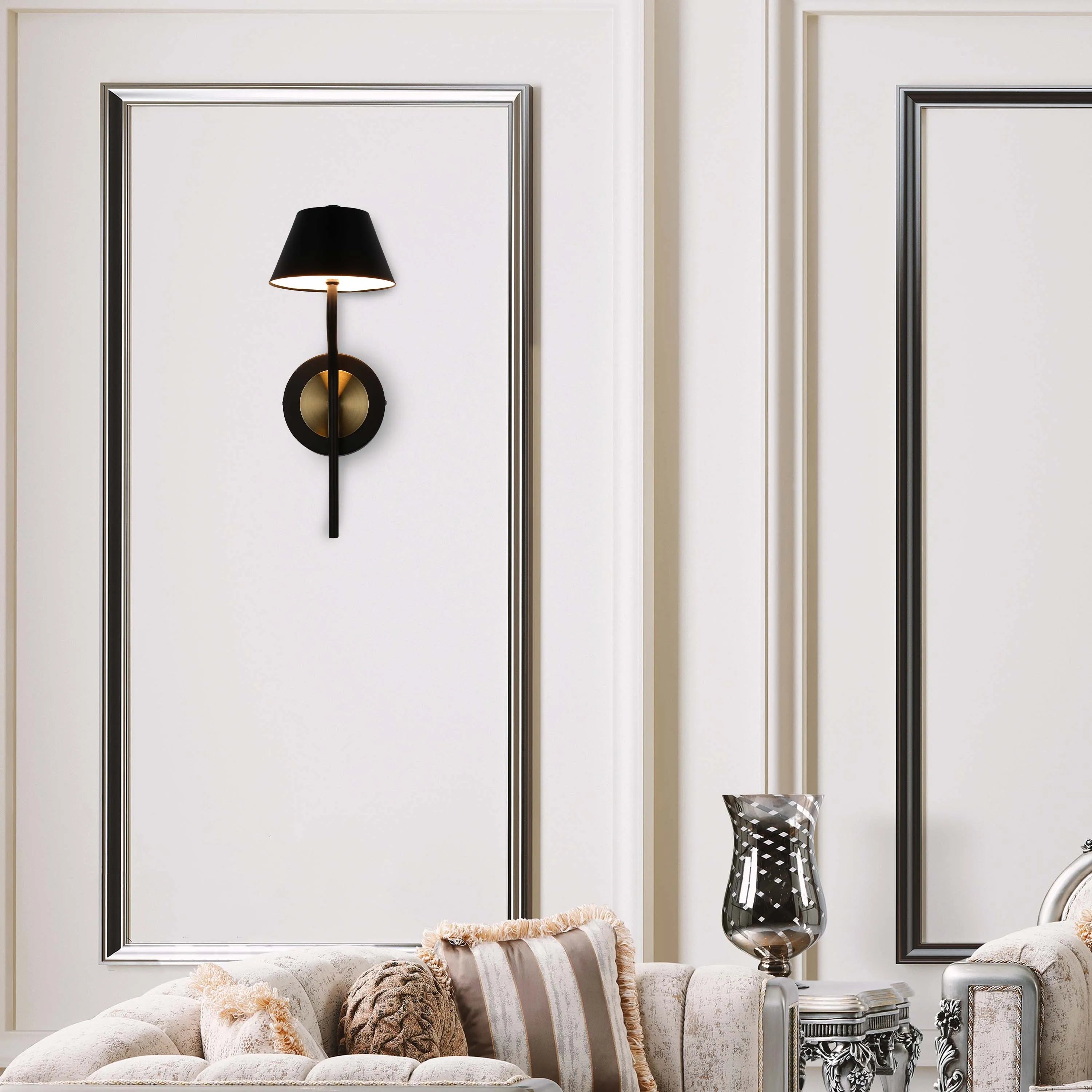 A sophisticated wall light with a black shade and brass detailing, creating a warm and inviting ambience in a modern setting.