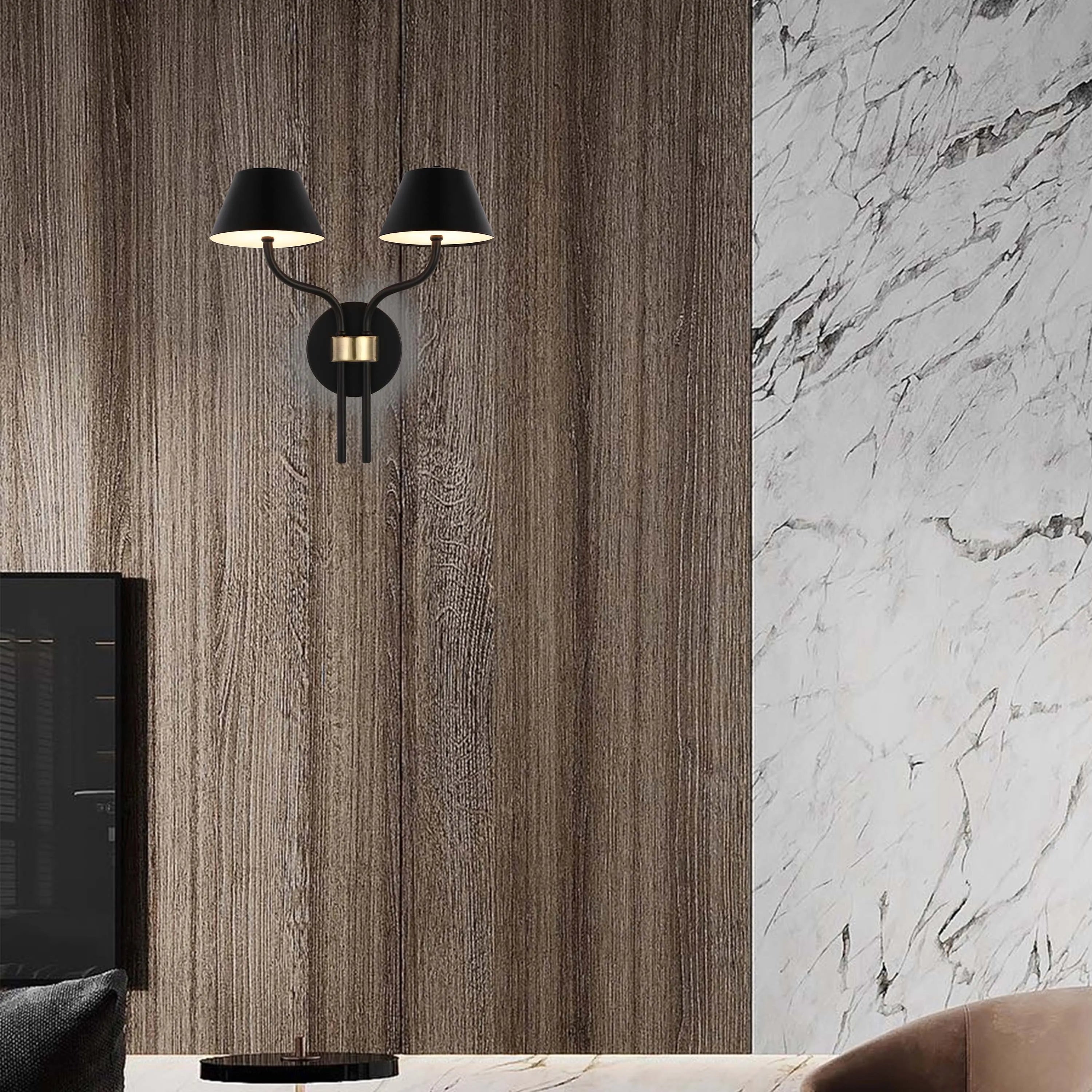 A striking twin wall light with black shades and brass detailing, casting a warm glow against a textured wooden wall.