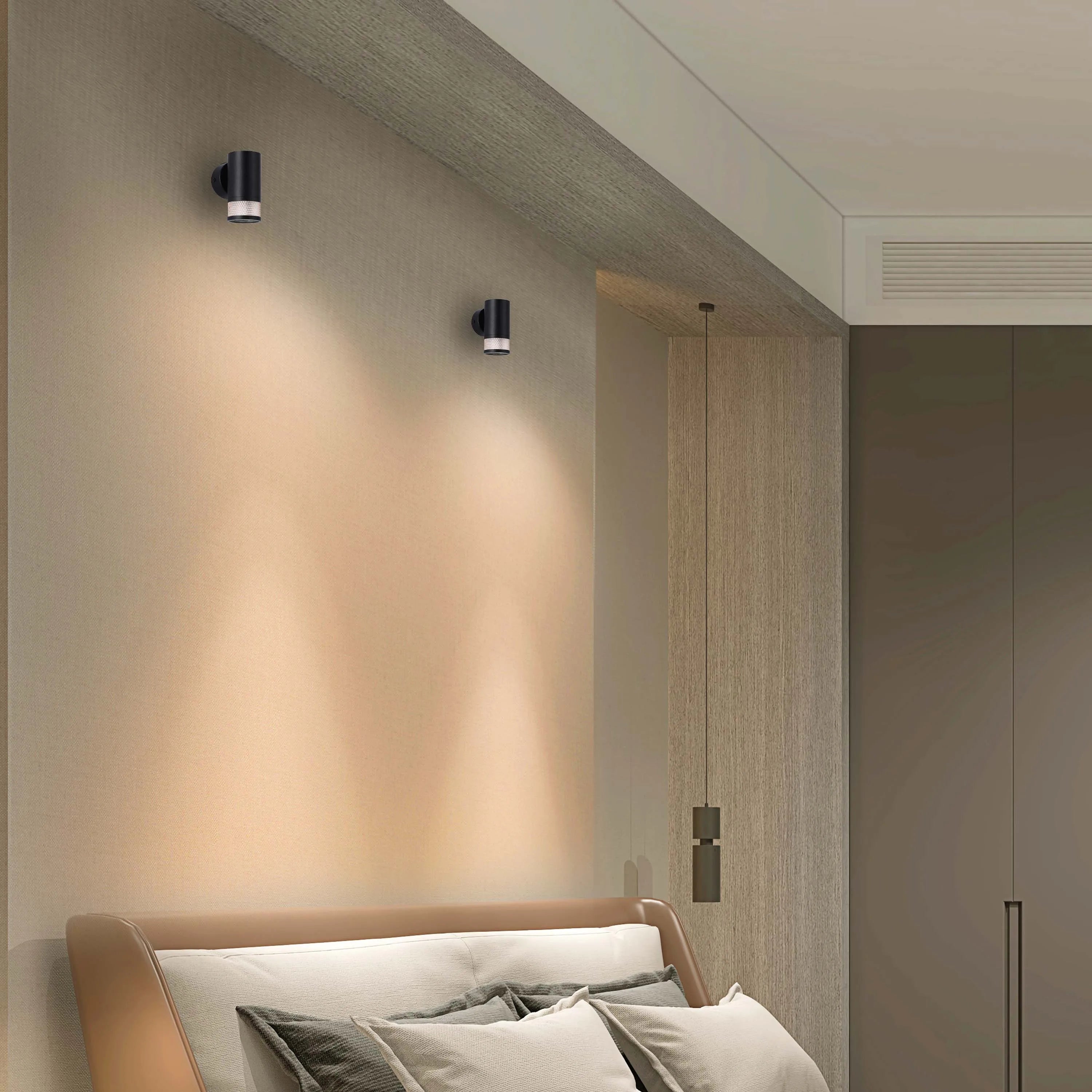 Modern bedroom with wall-mounted lights providing soft illumination. Dark lights sit above the bed for reading or relaxing.