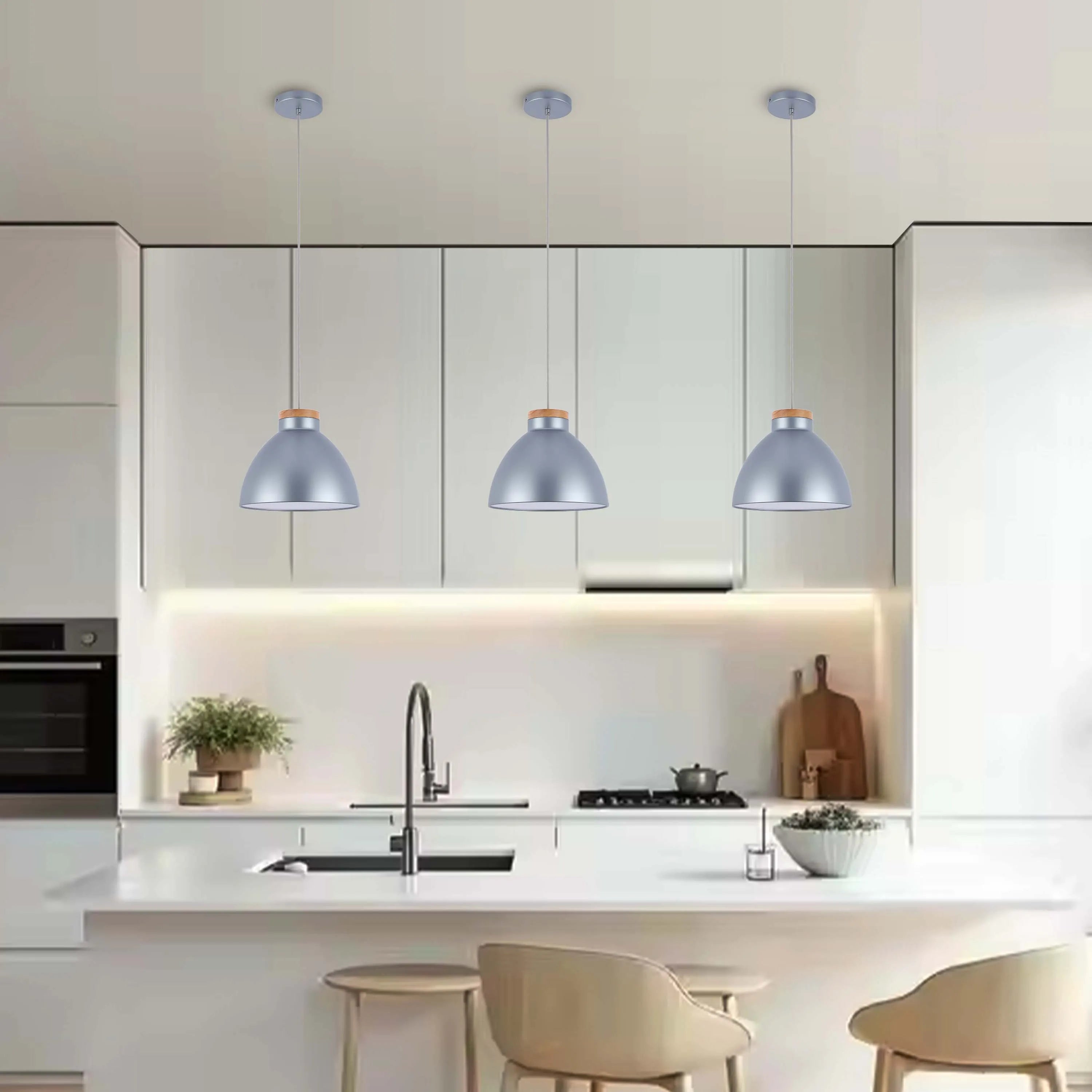 Three hanging pendant lights with a blue lampshade and light wood detailing illuminate a modern kitchen with white cabinets.