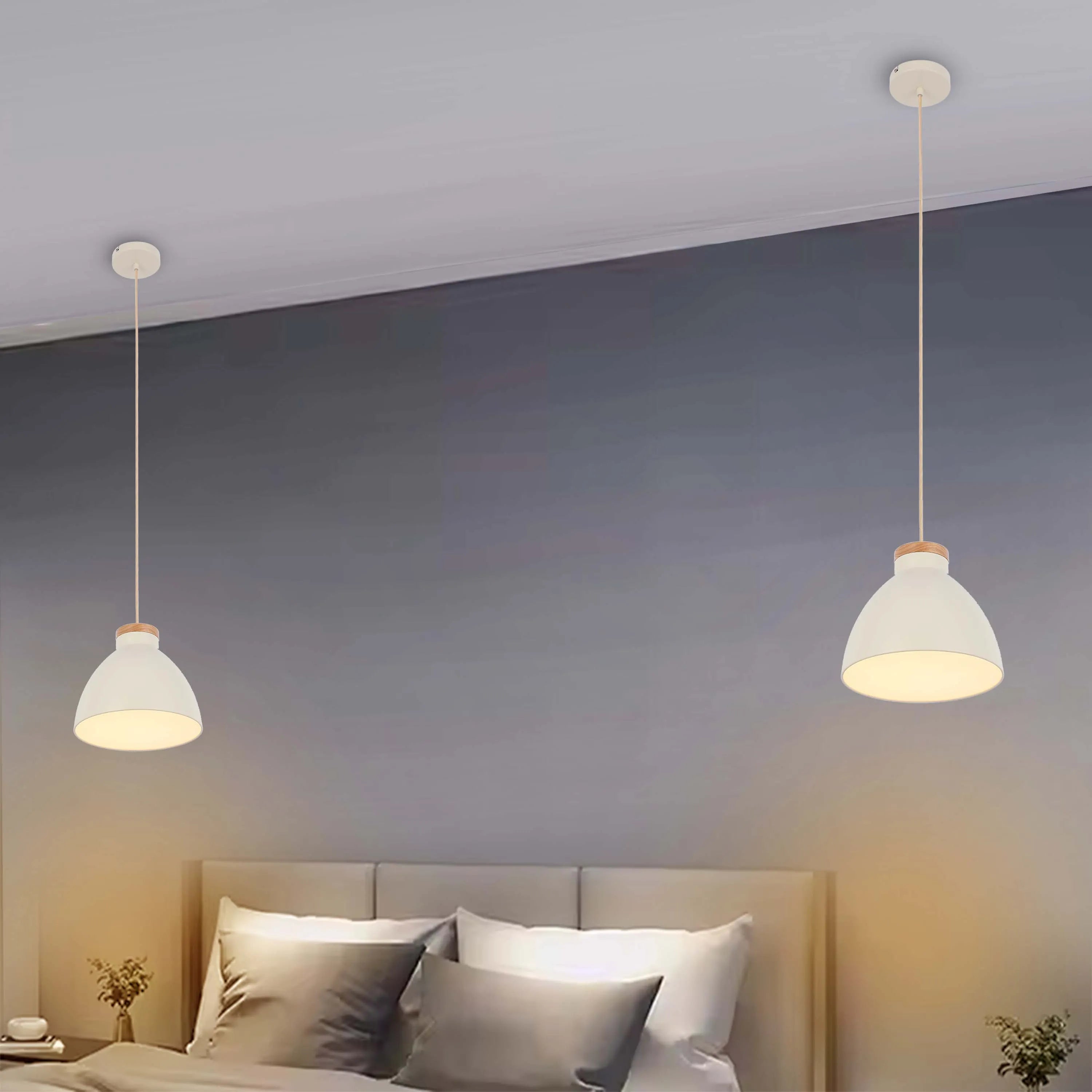 Two white pendant lights with wooden accents, hanging above a bed in a bedroom, emitting a soft, warm glow.