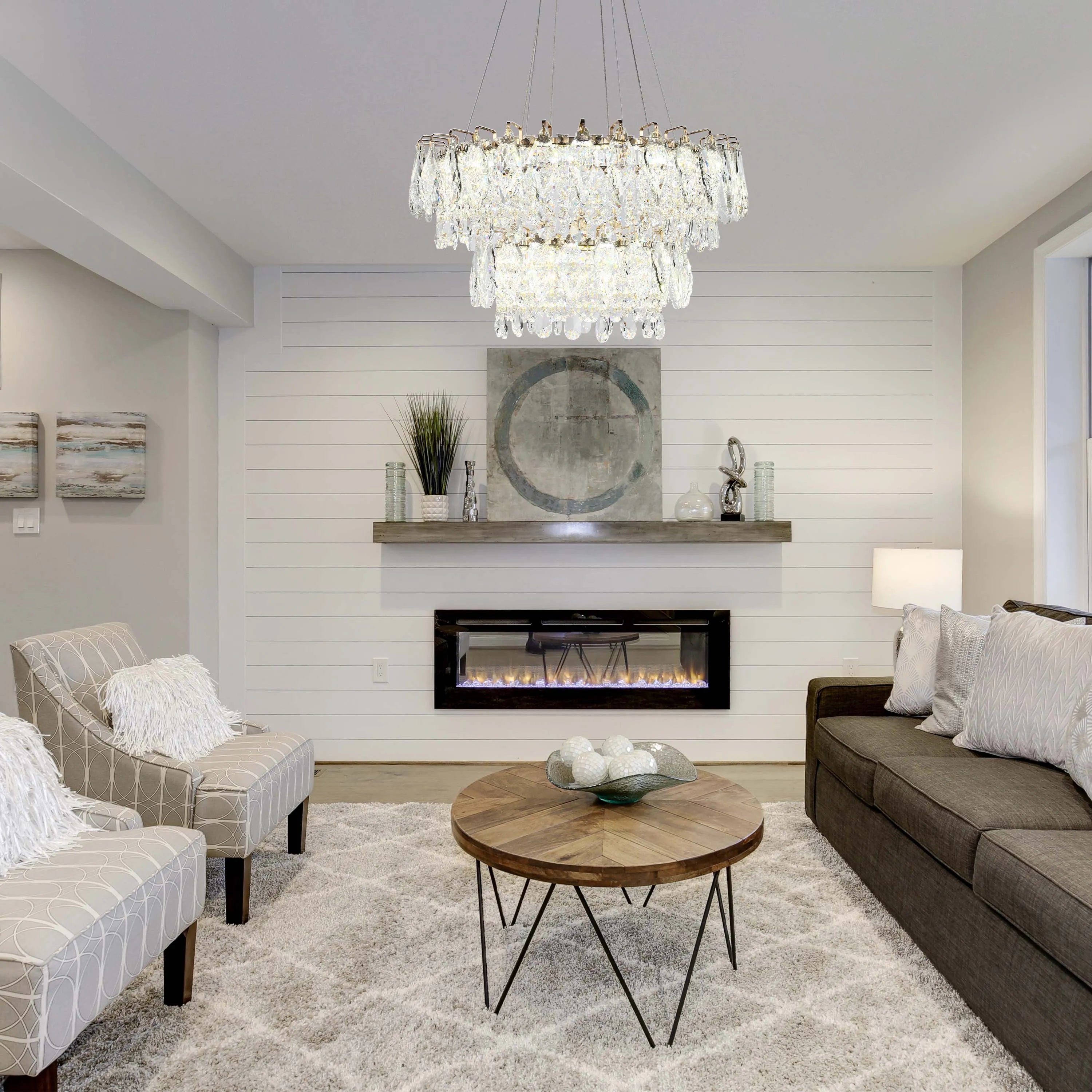 A multi-tiered crystal chandelier provides the focal point in this bright living room, creating a luxurious ambience.