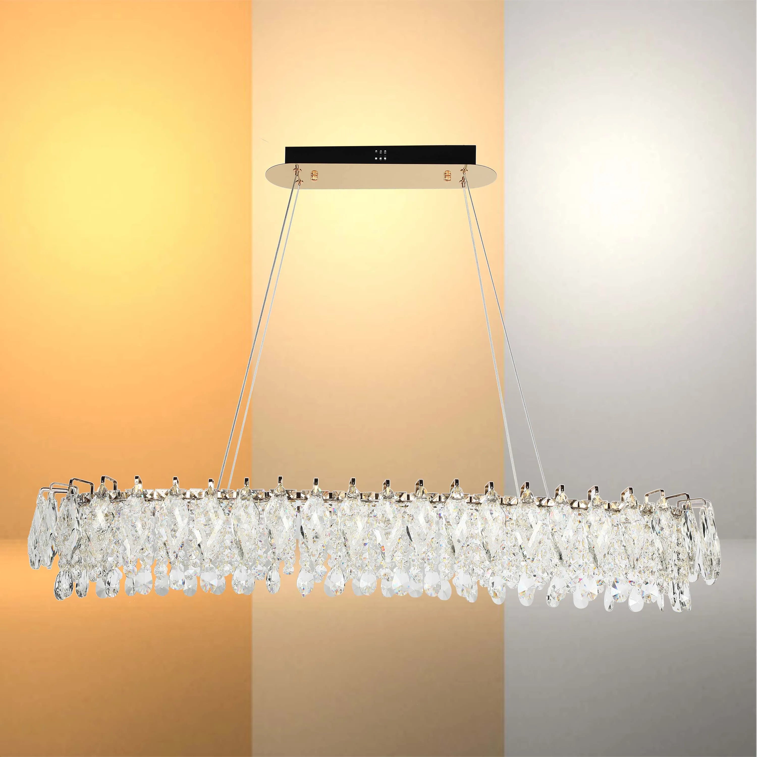 A modern, crystal pendant light fixture suspended by steel cables, showcasing different light temperatures.