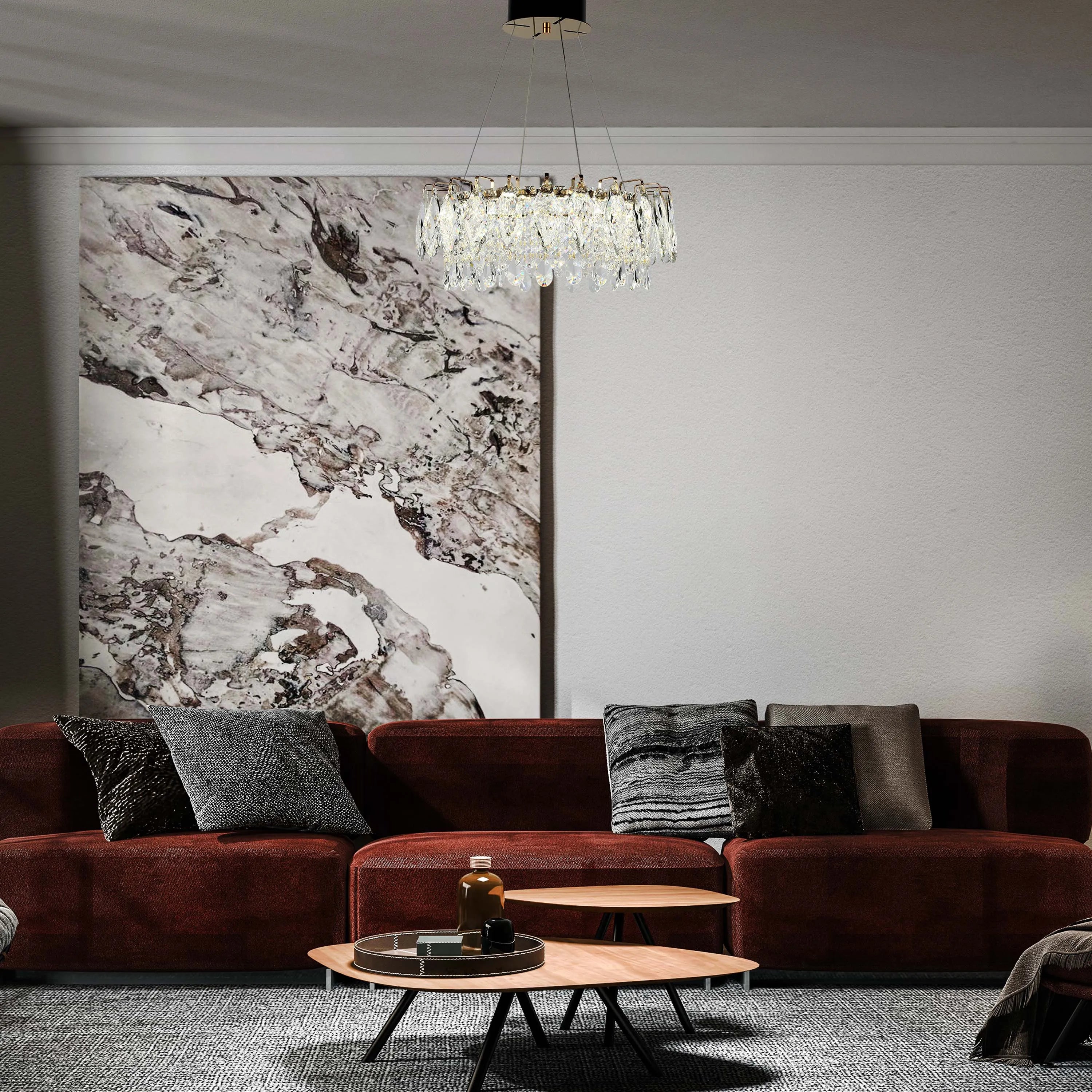 A round crystal chandelier hangs above a plush, reddish-brown sofa, creating a warm and inviting ambience in the living room.