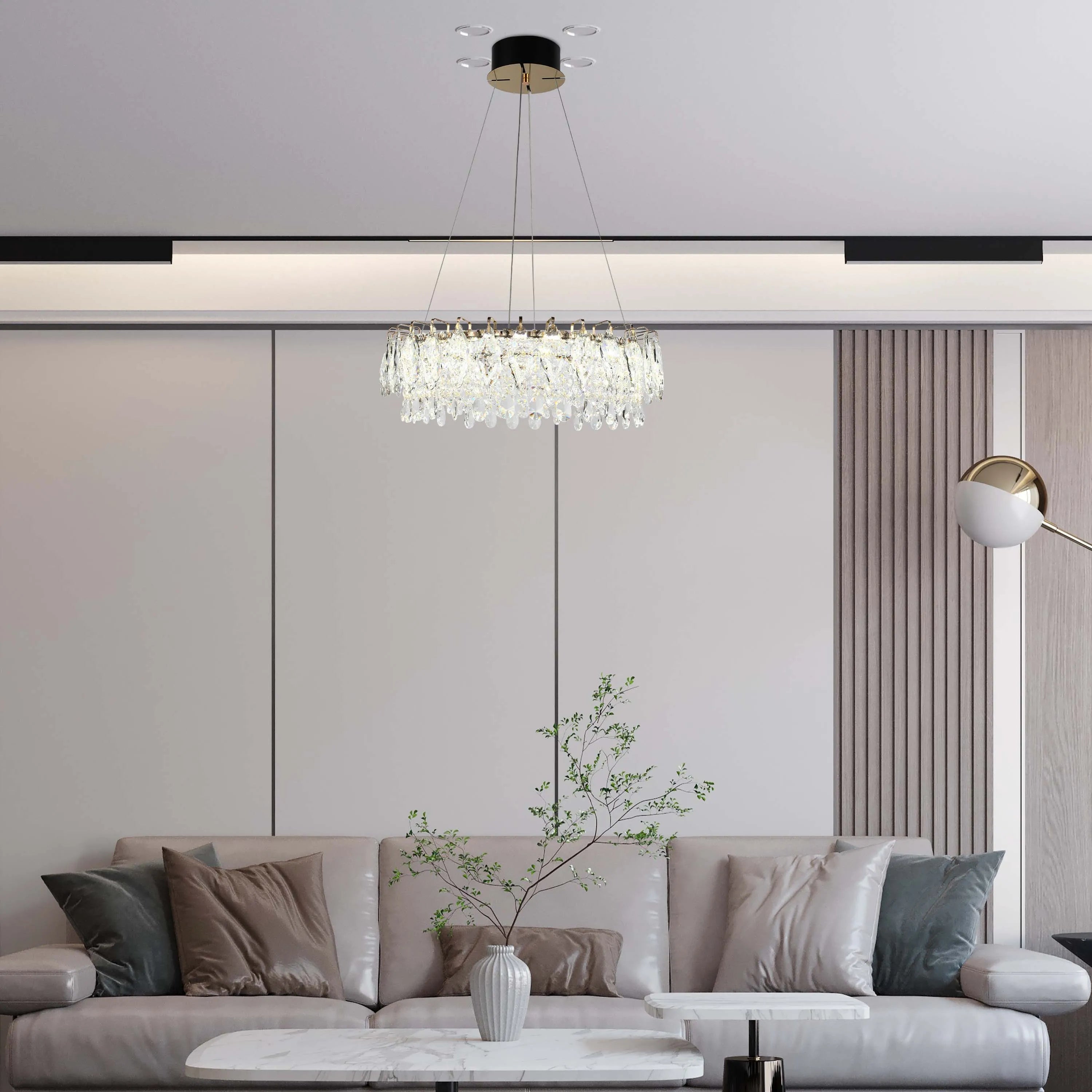 Contemporary living room showcasing a crystal chandelier, recessed lighting, and a stylish floor lamp for a modern ambiance.