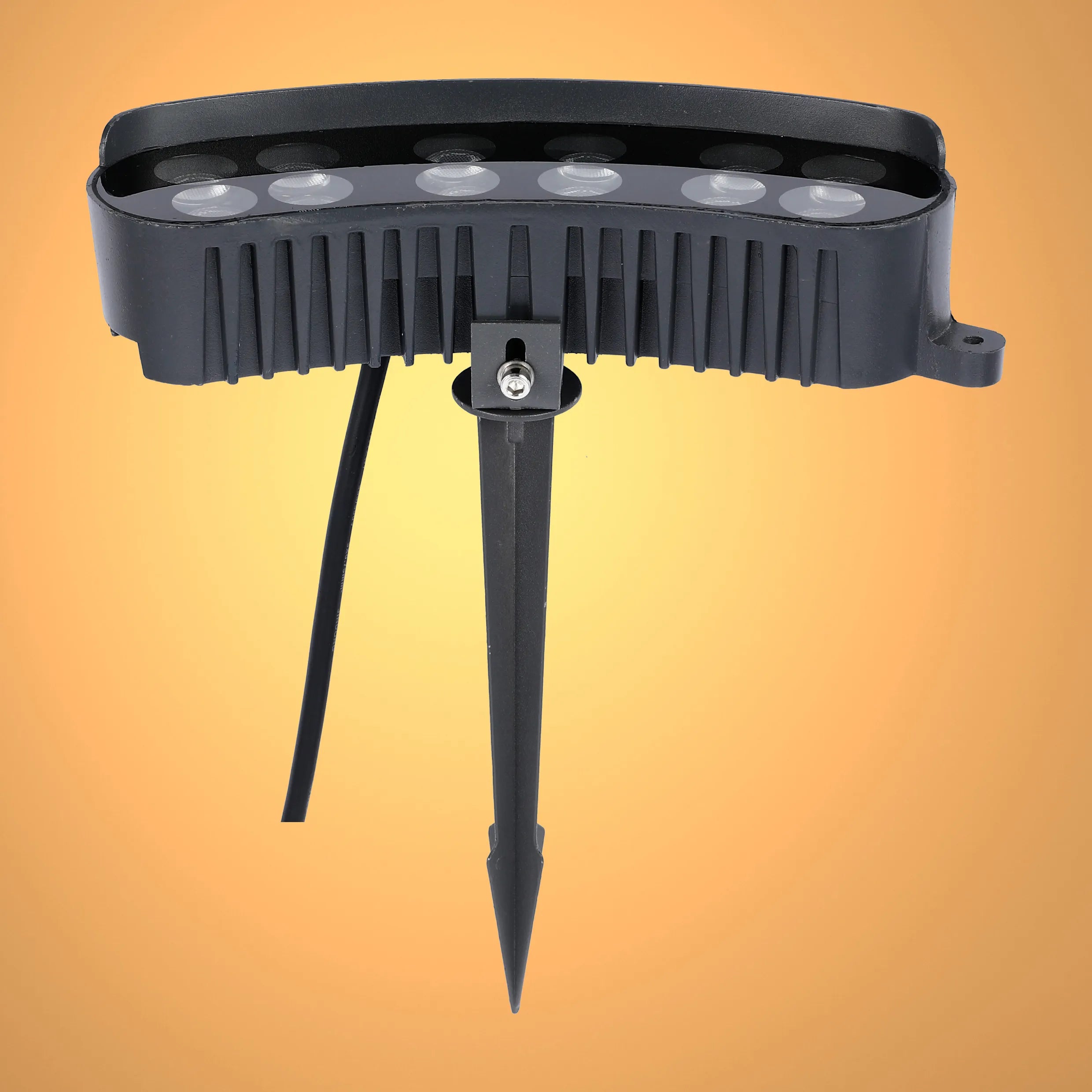 Black outdoor LED spotlight with ground spike, set against a gradient yellow backdrop, showcasing outdoor garden lighting.