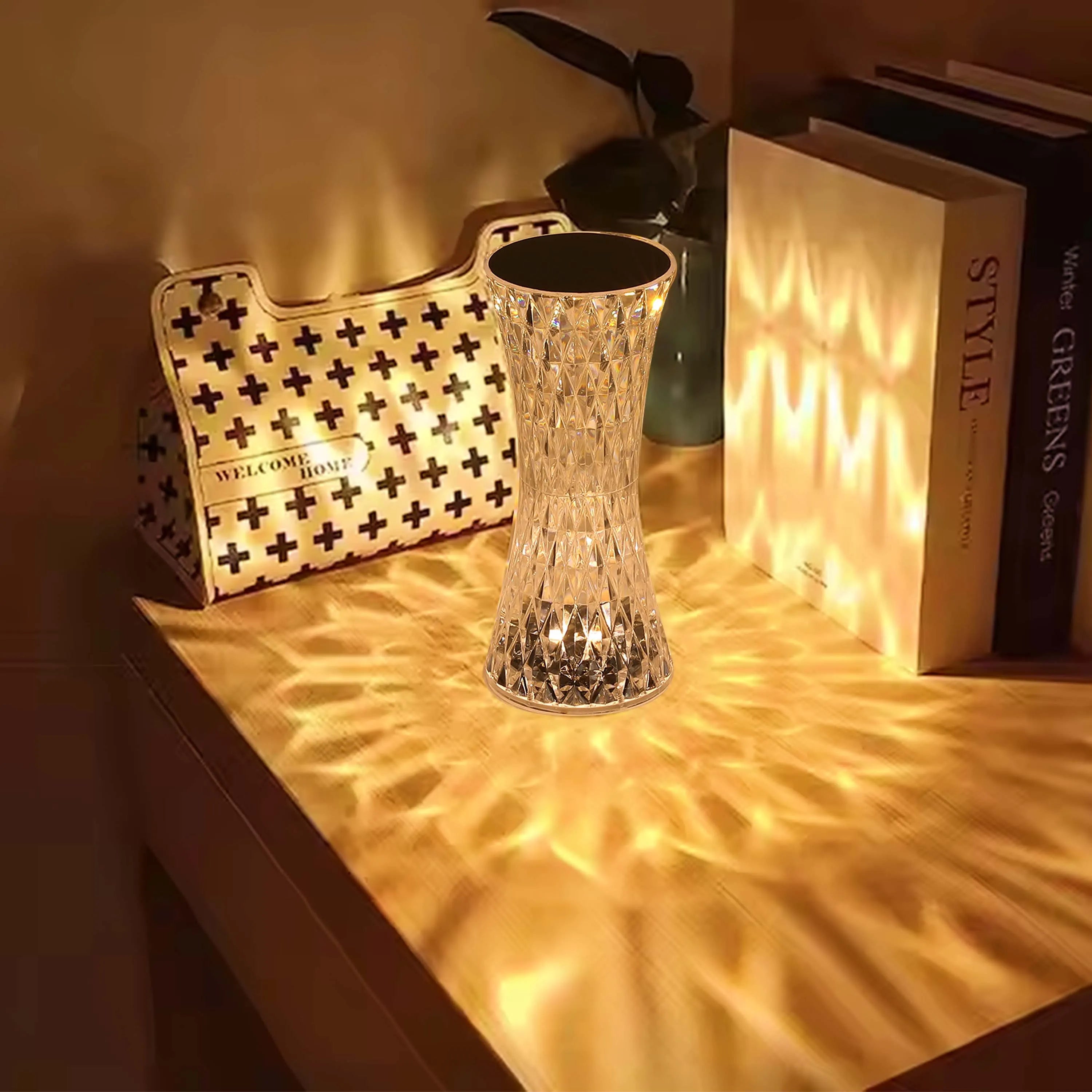 A dazzling, crystal-like lamp casts a warm, patterned glow across a wooden surface, creating an inviting atmosphere.