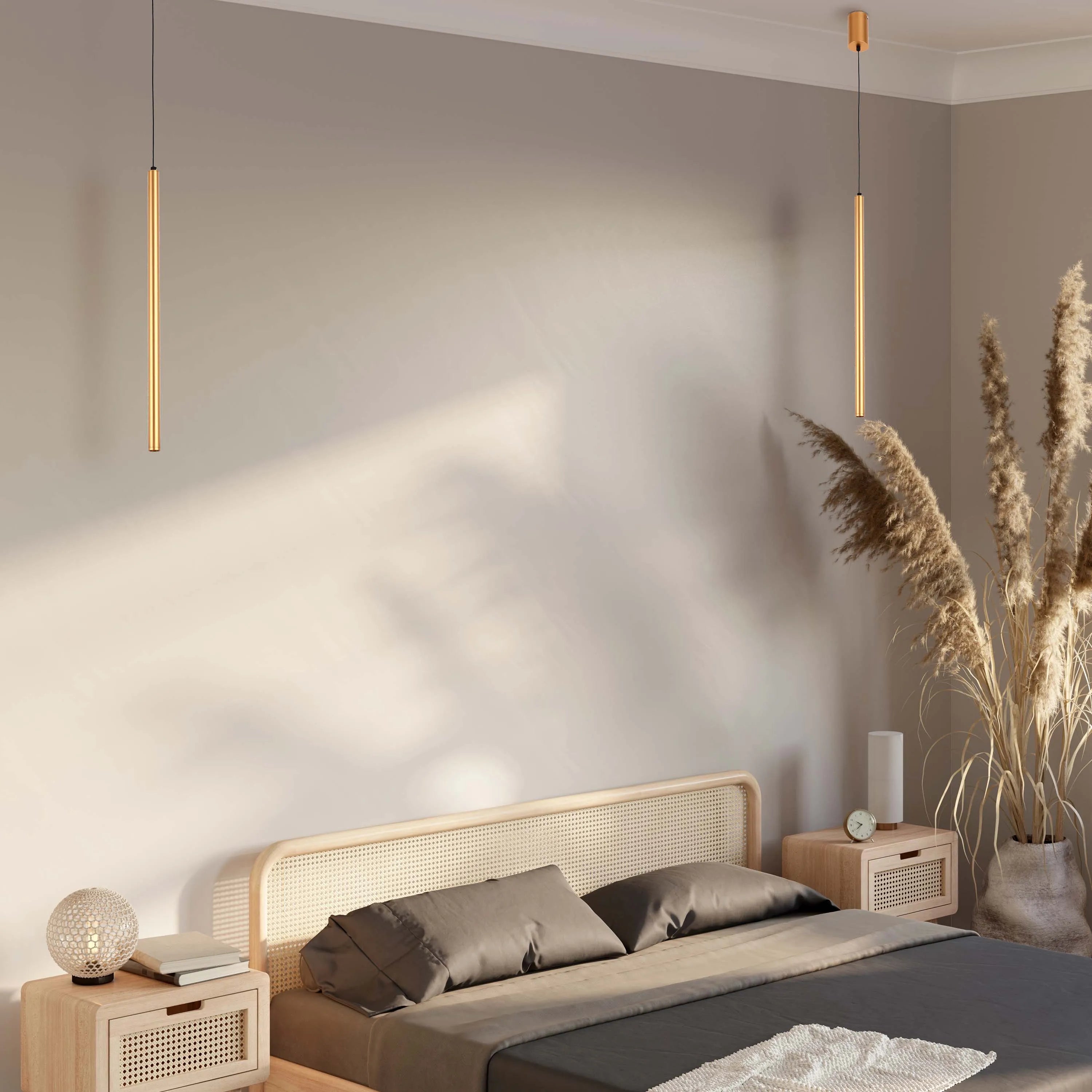 Bedroom with two gold pendant lights above a double bed with two wooden bedside tables on either side.