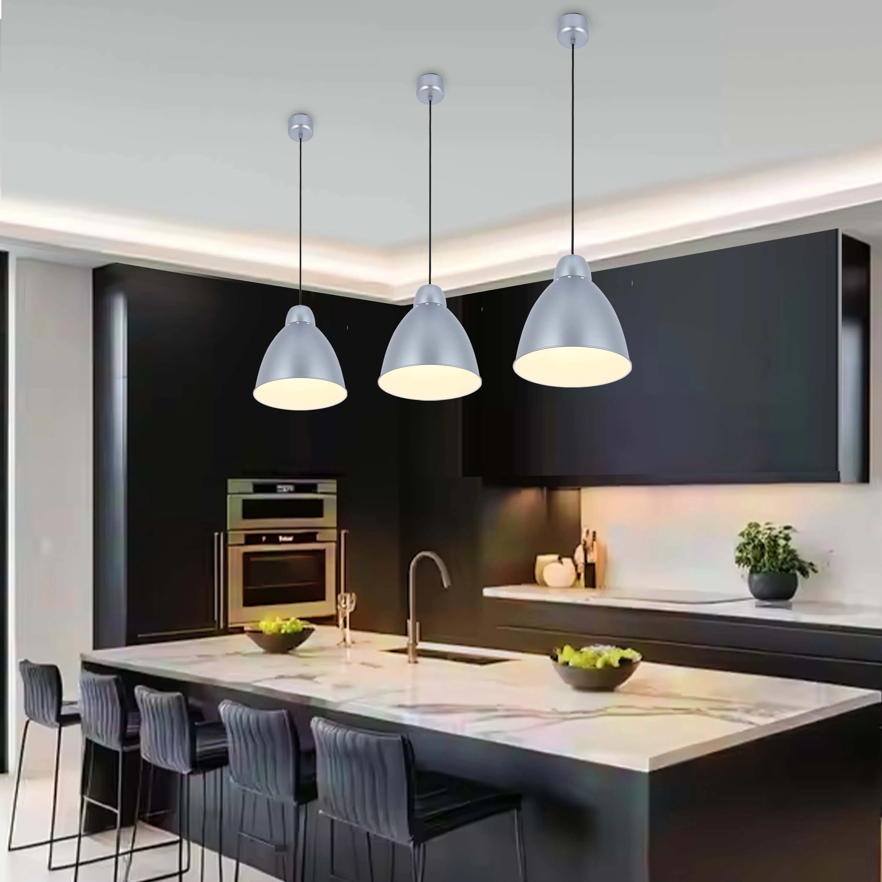Three pendant lights hang above a kitchen island. Silver, dome-shaped shades emit a warm glow, illuminating the marble countertop below.