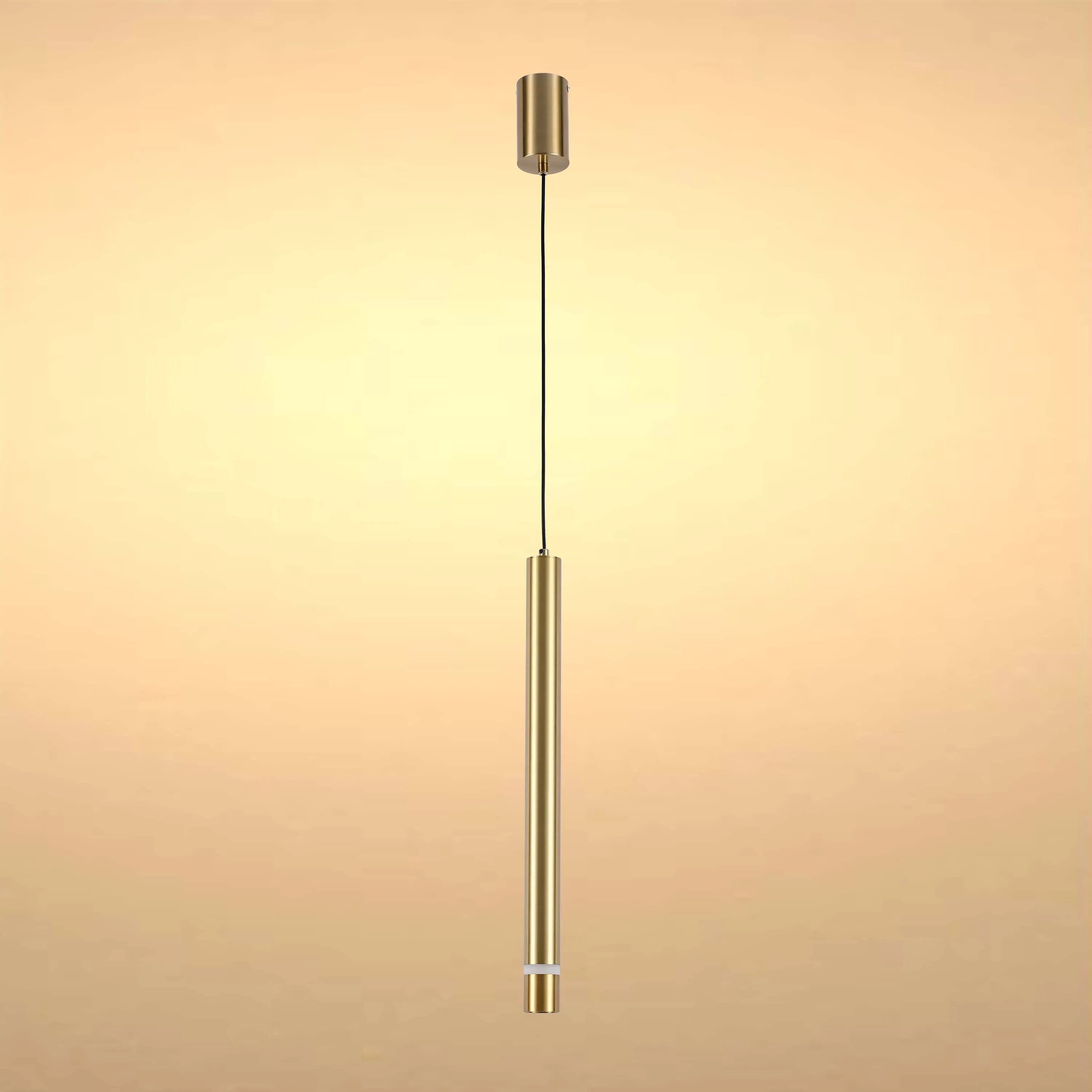 A brushed gold pendant light hangs against a subtle gold backdrop, simple and modern.