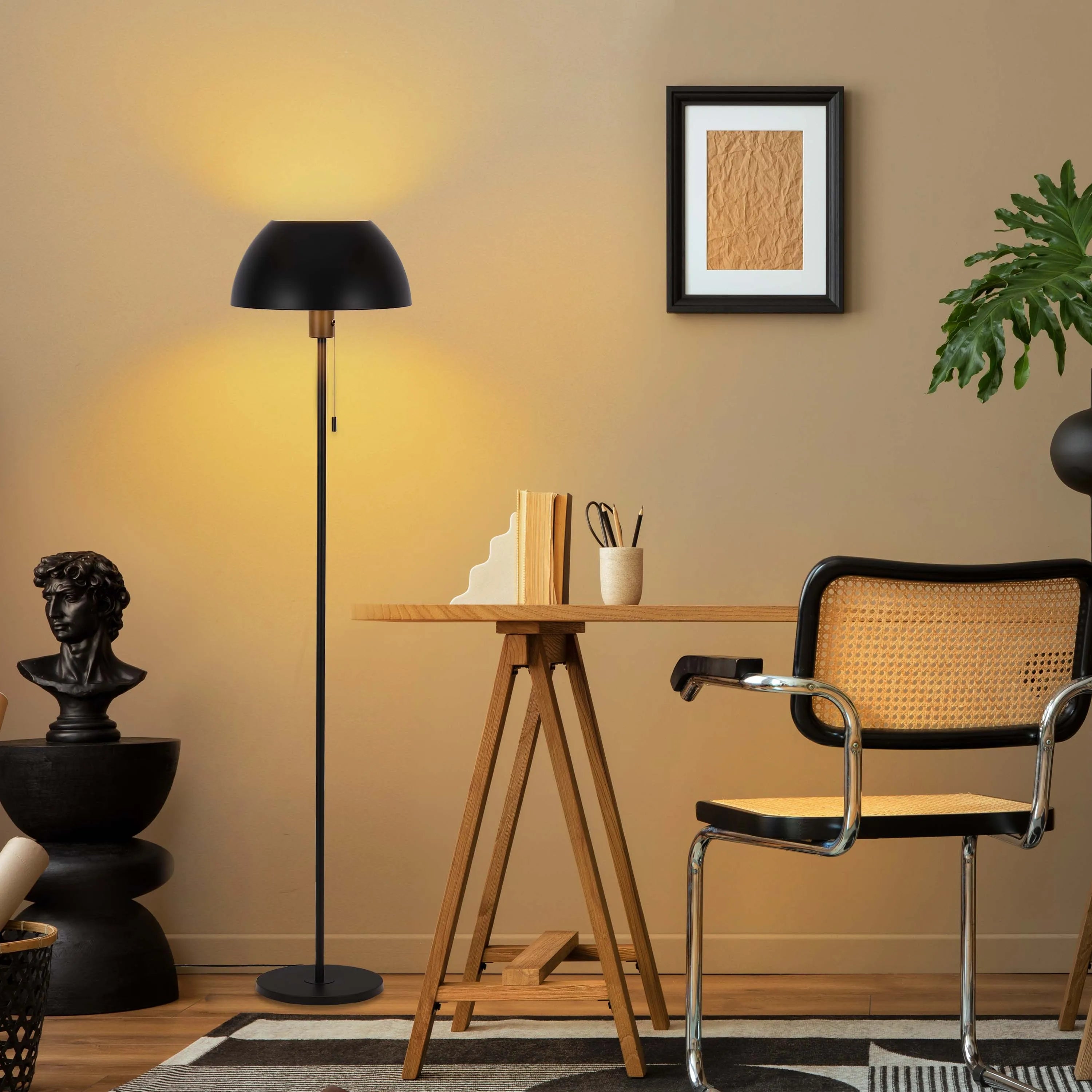 A stylish black dome floor lamp provides warm ambient light in this modern interior. The light casts a soft glow, creating a cosy atmosphere.