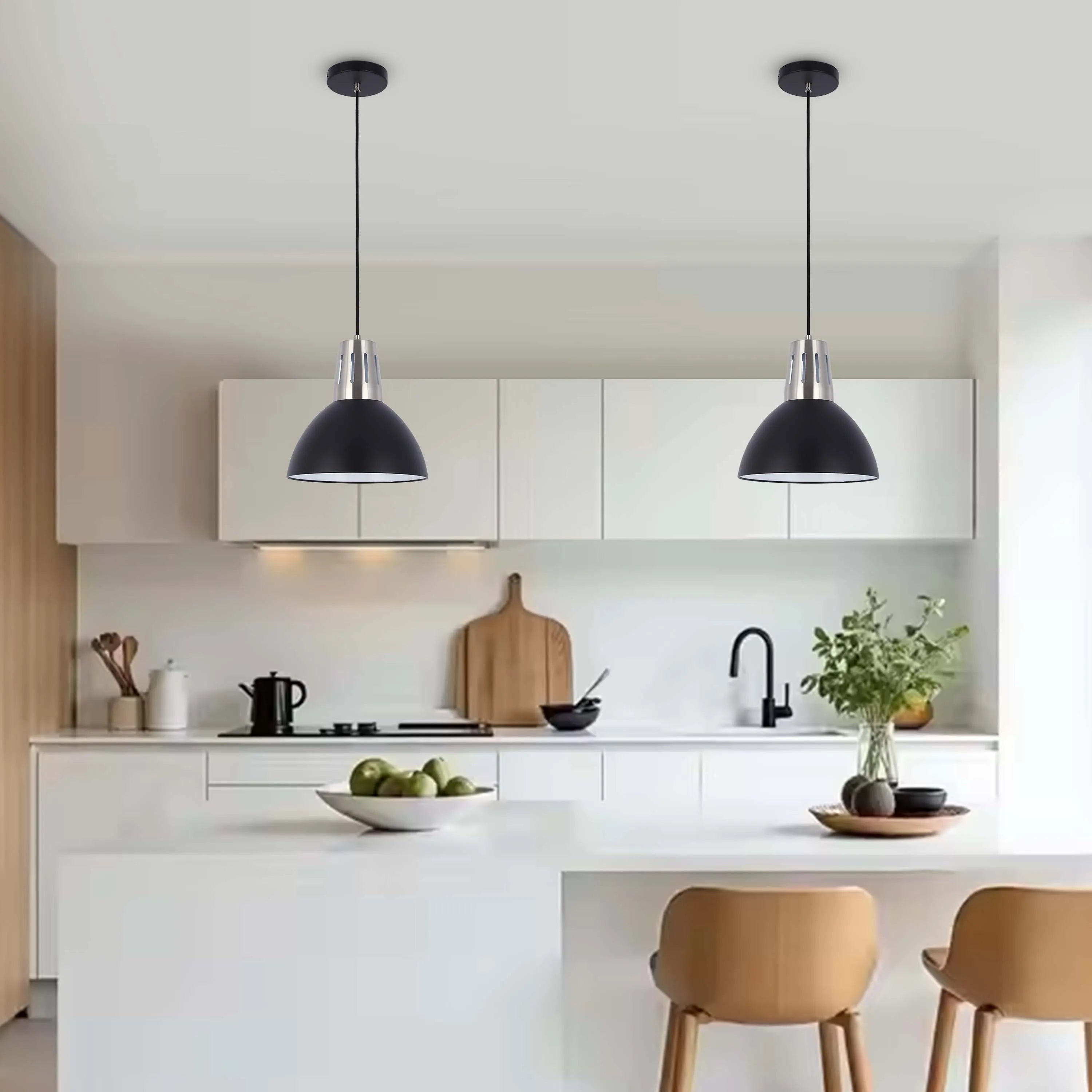 Two black pendant lights hang over a kitchen island, offering focused task lighting with a sleek and modern industrial design.