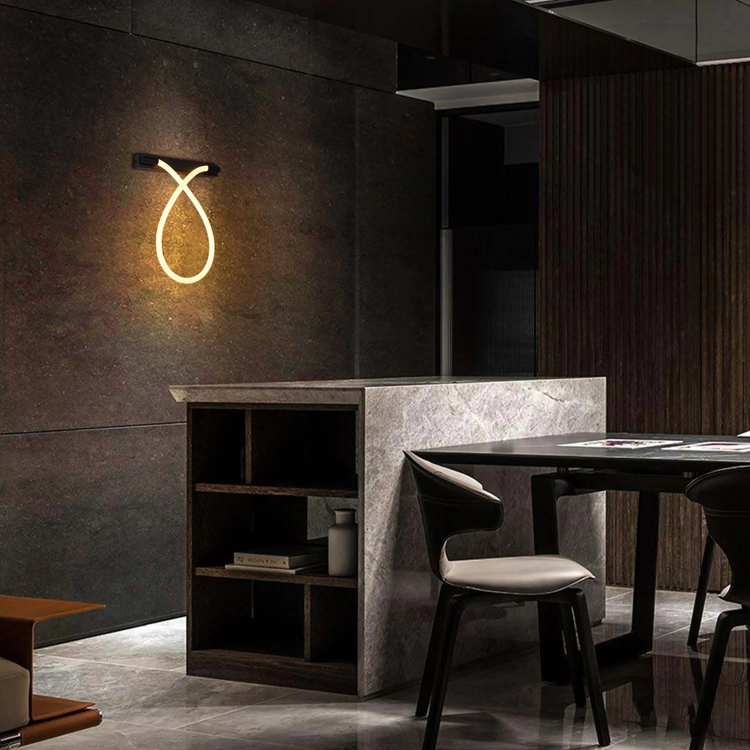 A stylish interior featuring a modern light fixture resembling an illuminated loop on a textured wall, creating warm ambience.