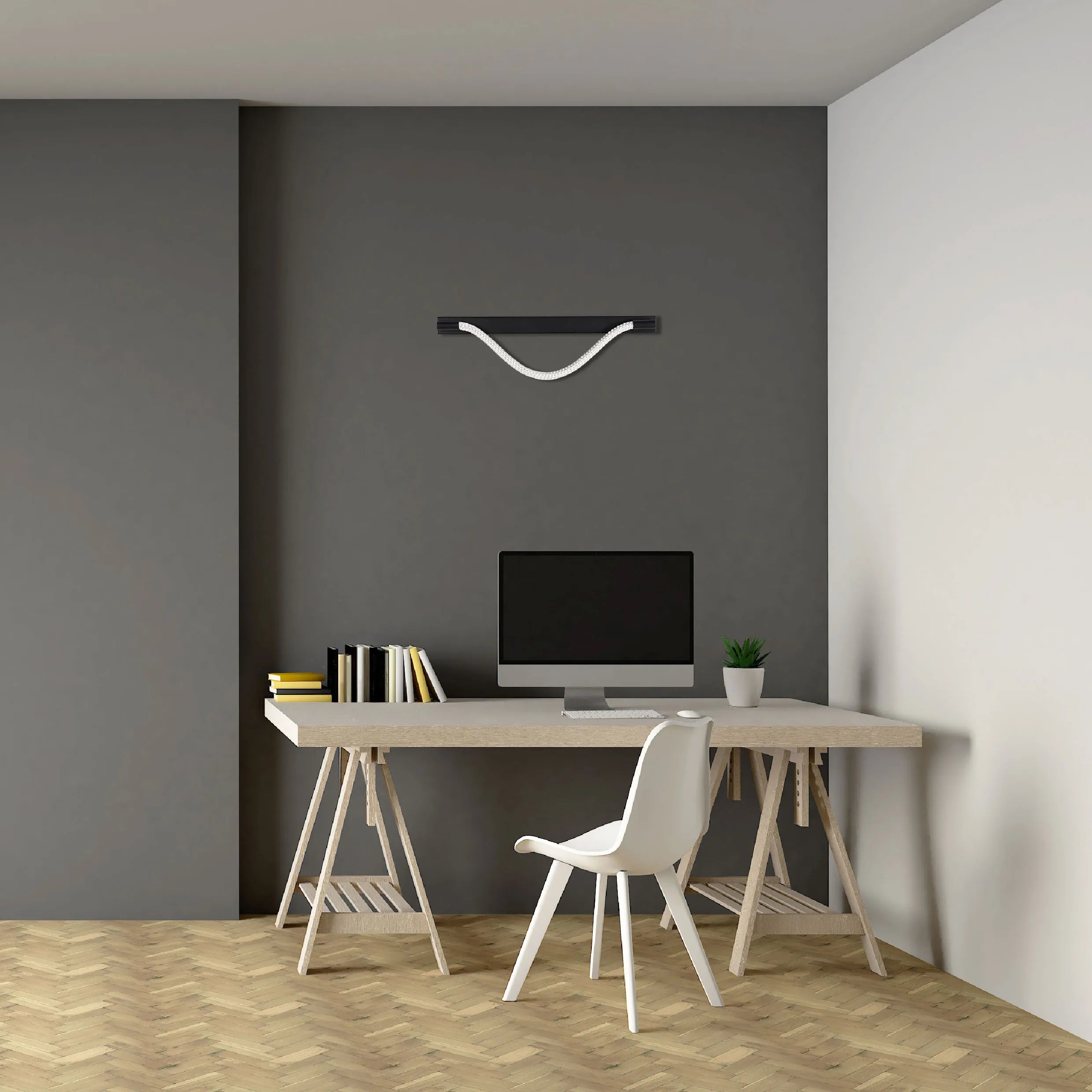 Modern desk setup featuring a sleek black pendant light with a white, curved rope accent, illuminating the workspace below.
