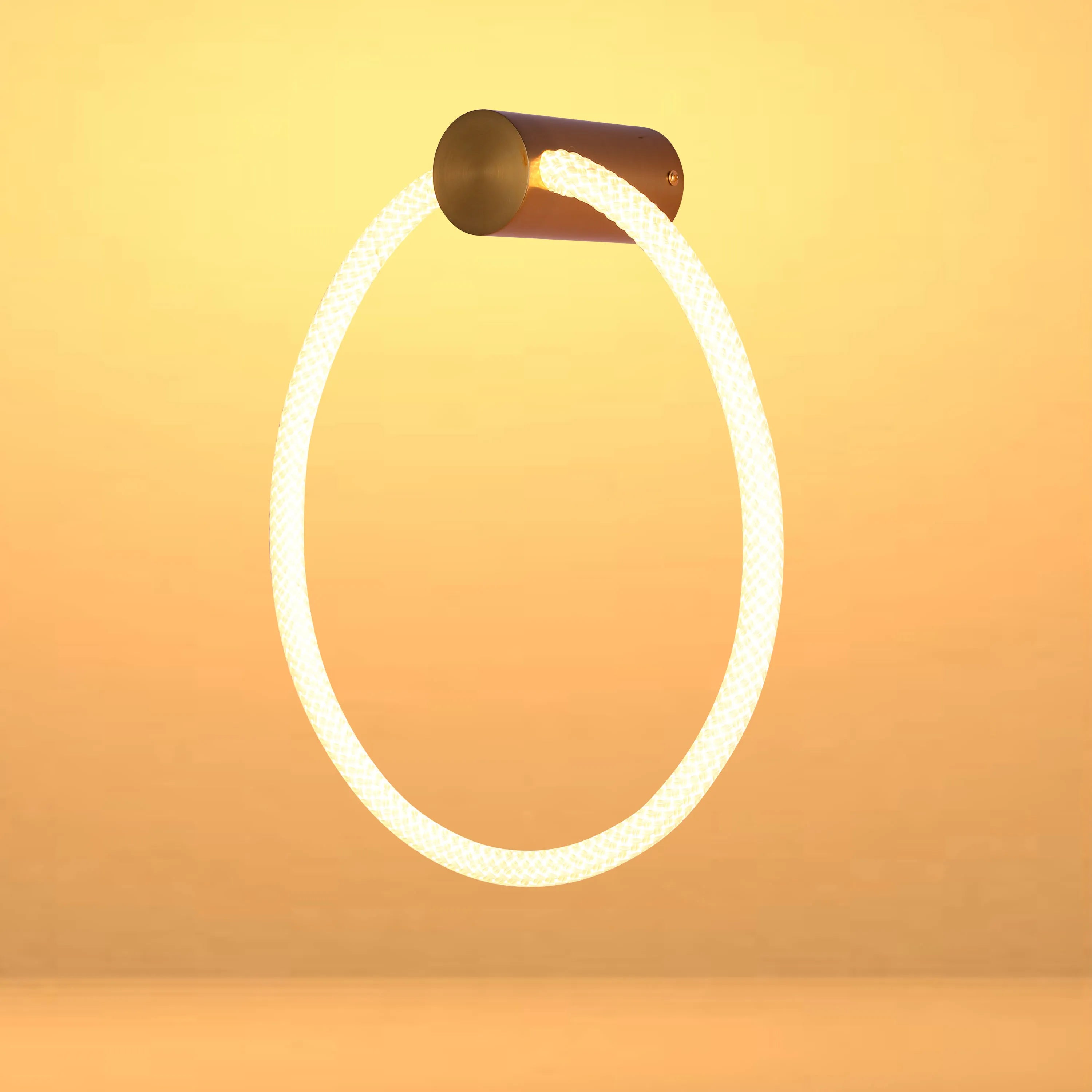 Circular rope light fixed to a brass mount. Warm, diffused light fills the frame, creating a cosy and inviting ambience.