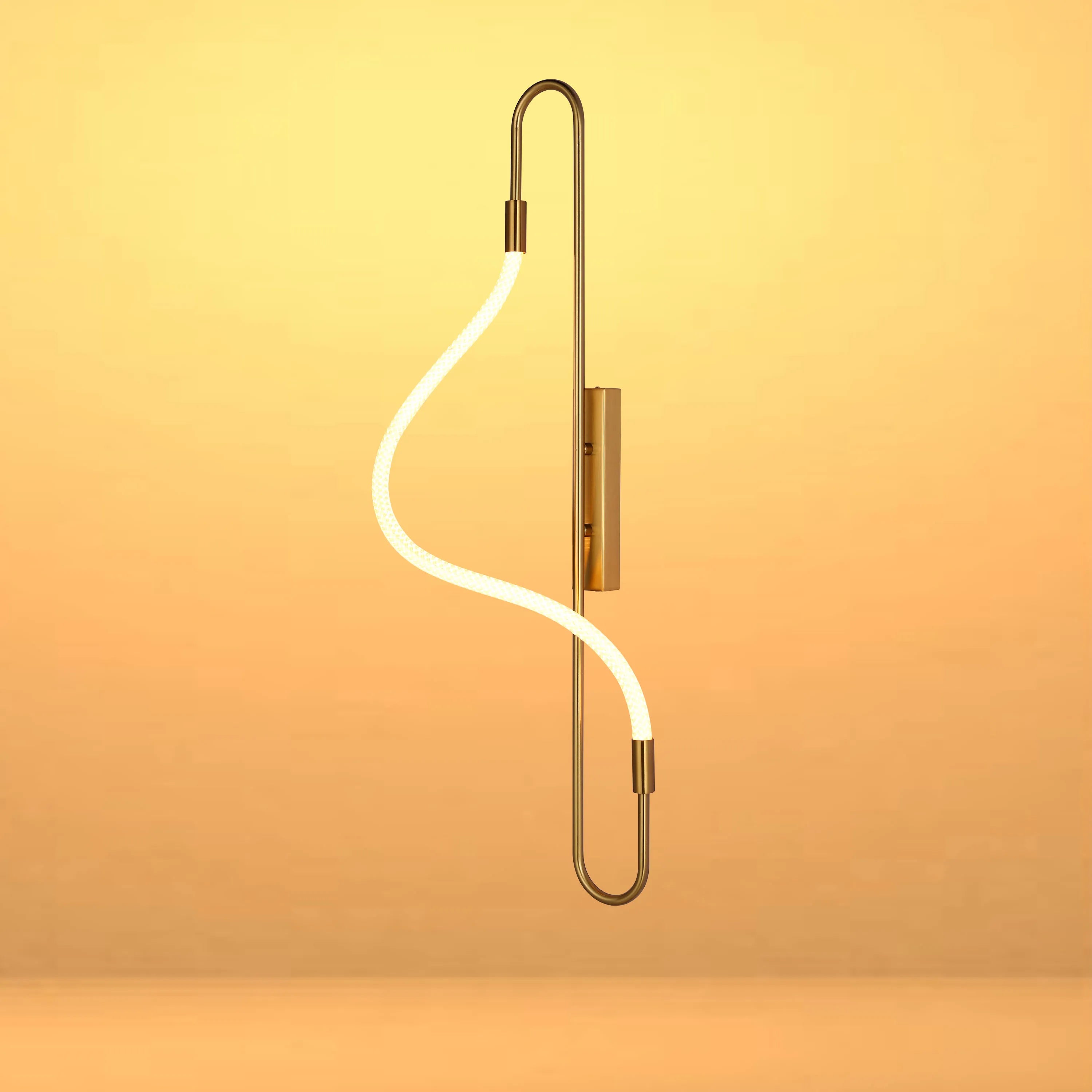 A striking wall light with a brass frame and a looping, glowing rope light. Modern, stylish, and a statement piece.