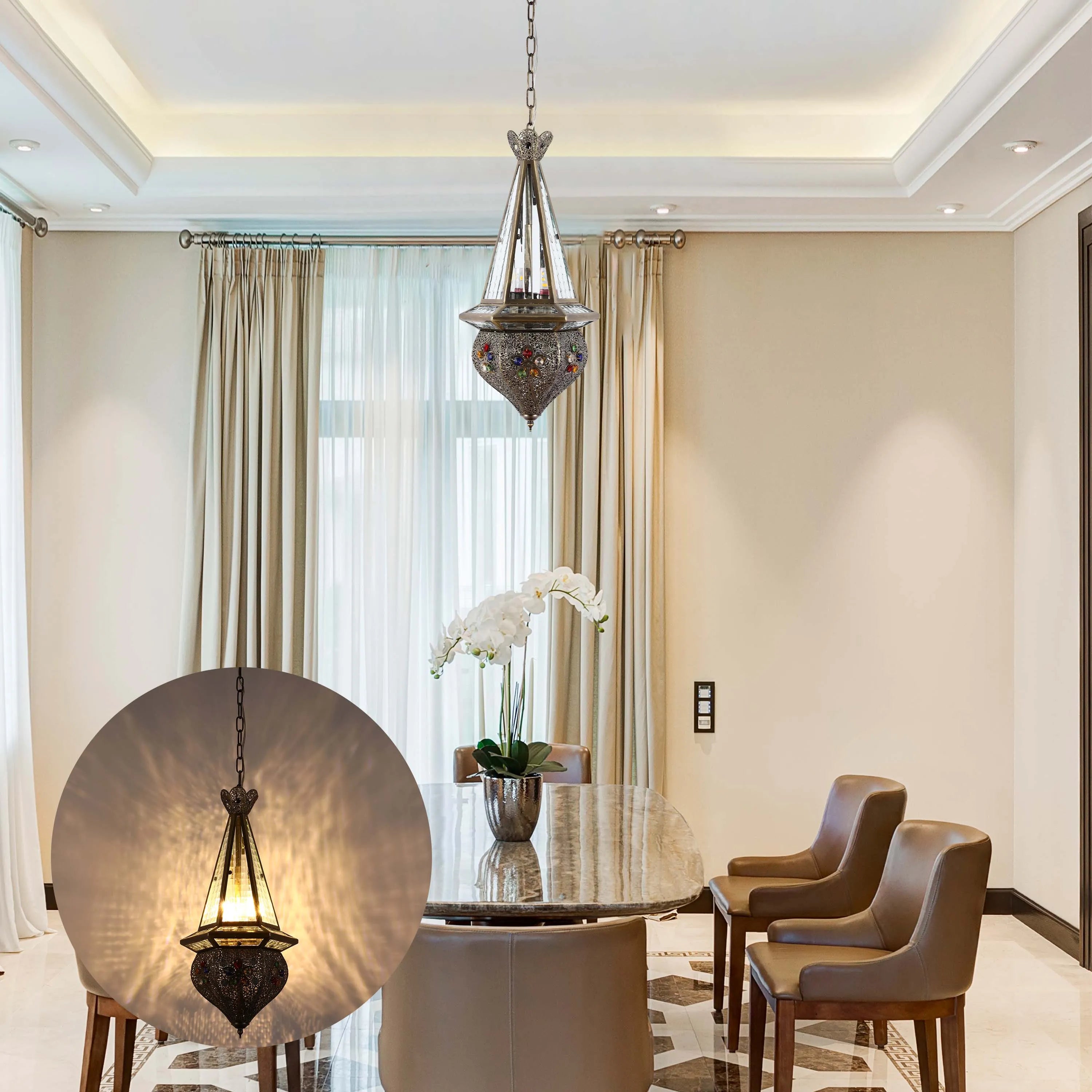 An ornate, colourful, glass and metal pendant light hangs above a dining table in an elegant, neutral toned dining room.