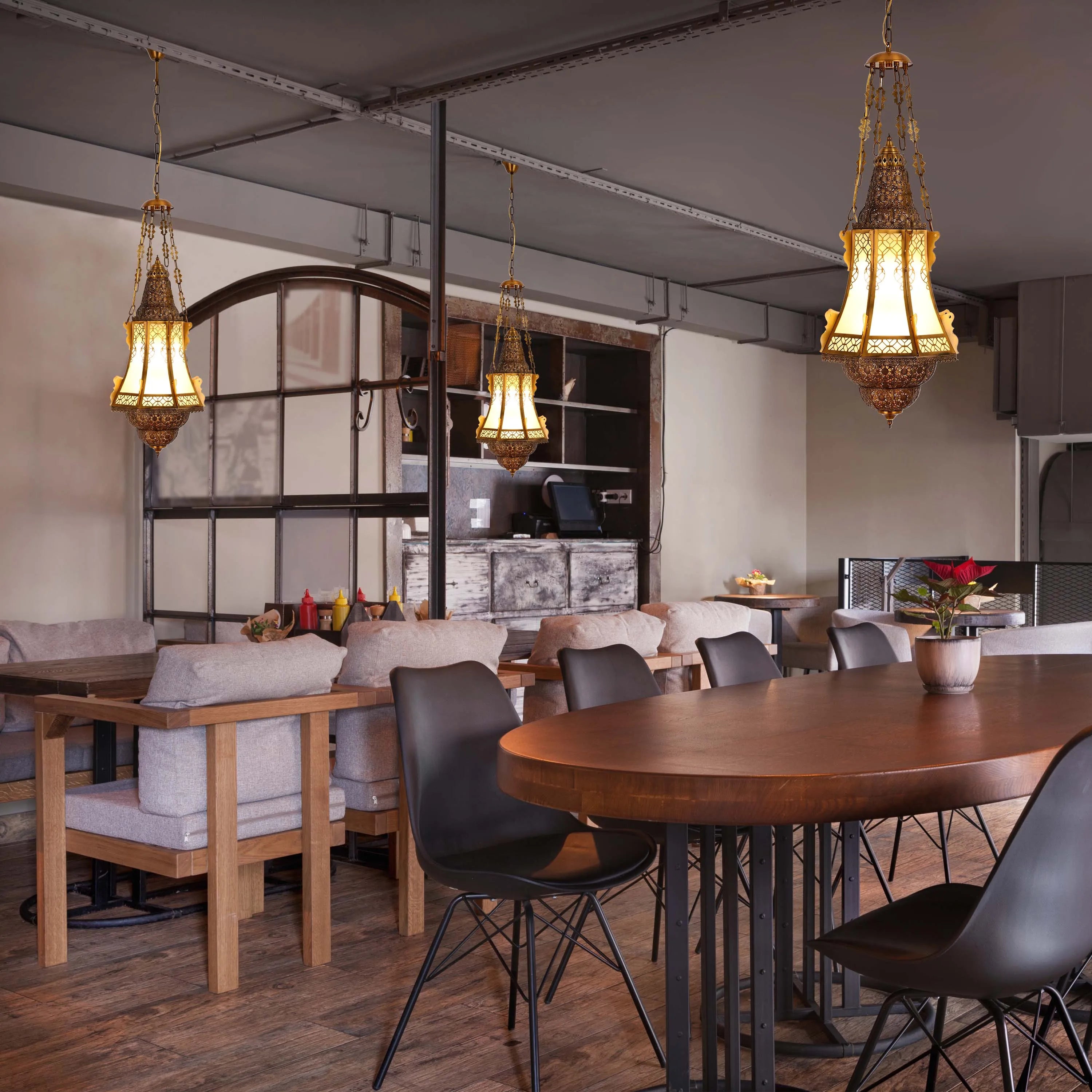 Elegant, ornate pendant lights with decorative detailing illuminating the dining area, creating a warm, inviting atmosphere.