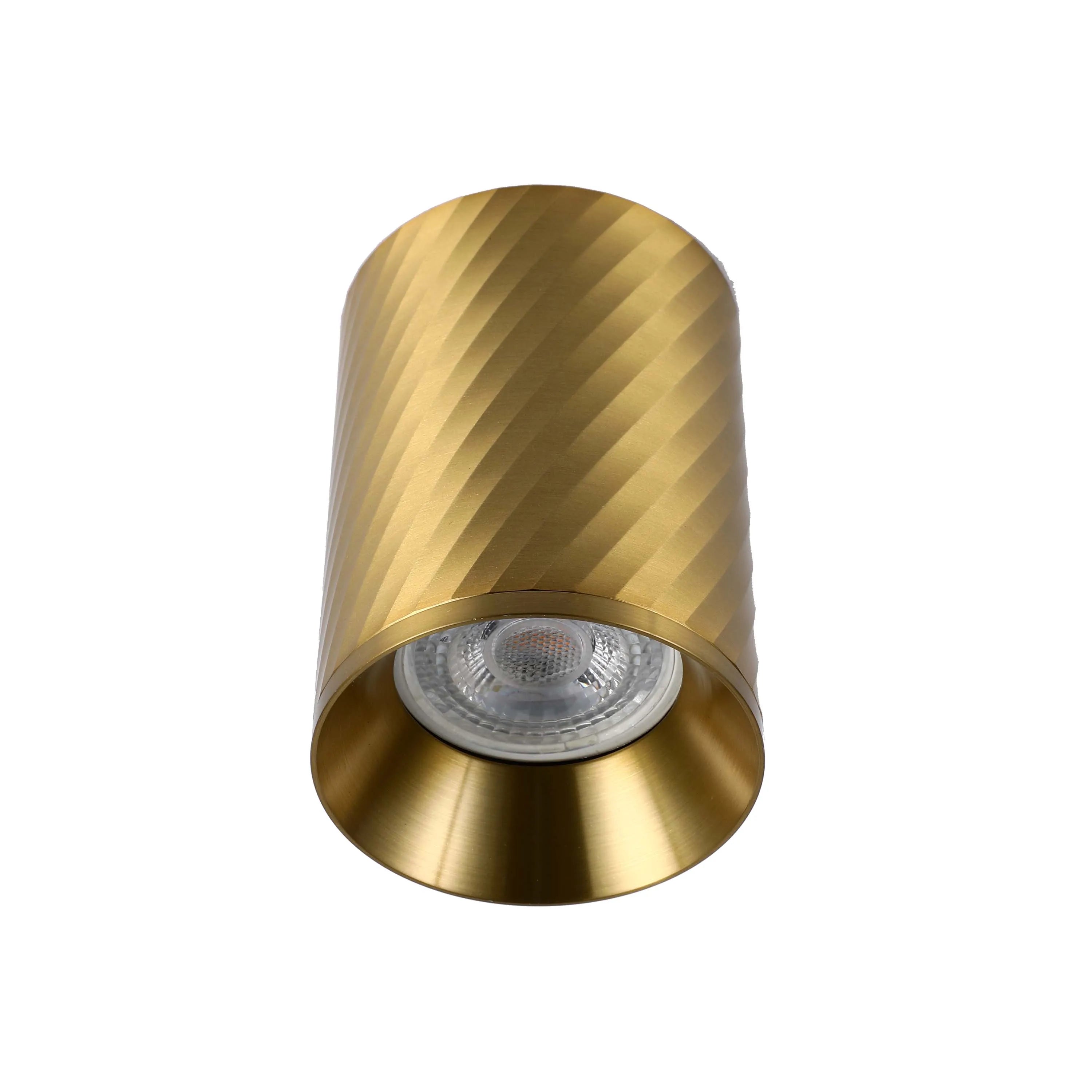 A gold, cylindrical, textured downlight that is recessed for a soft, glare-free glow.