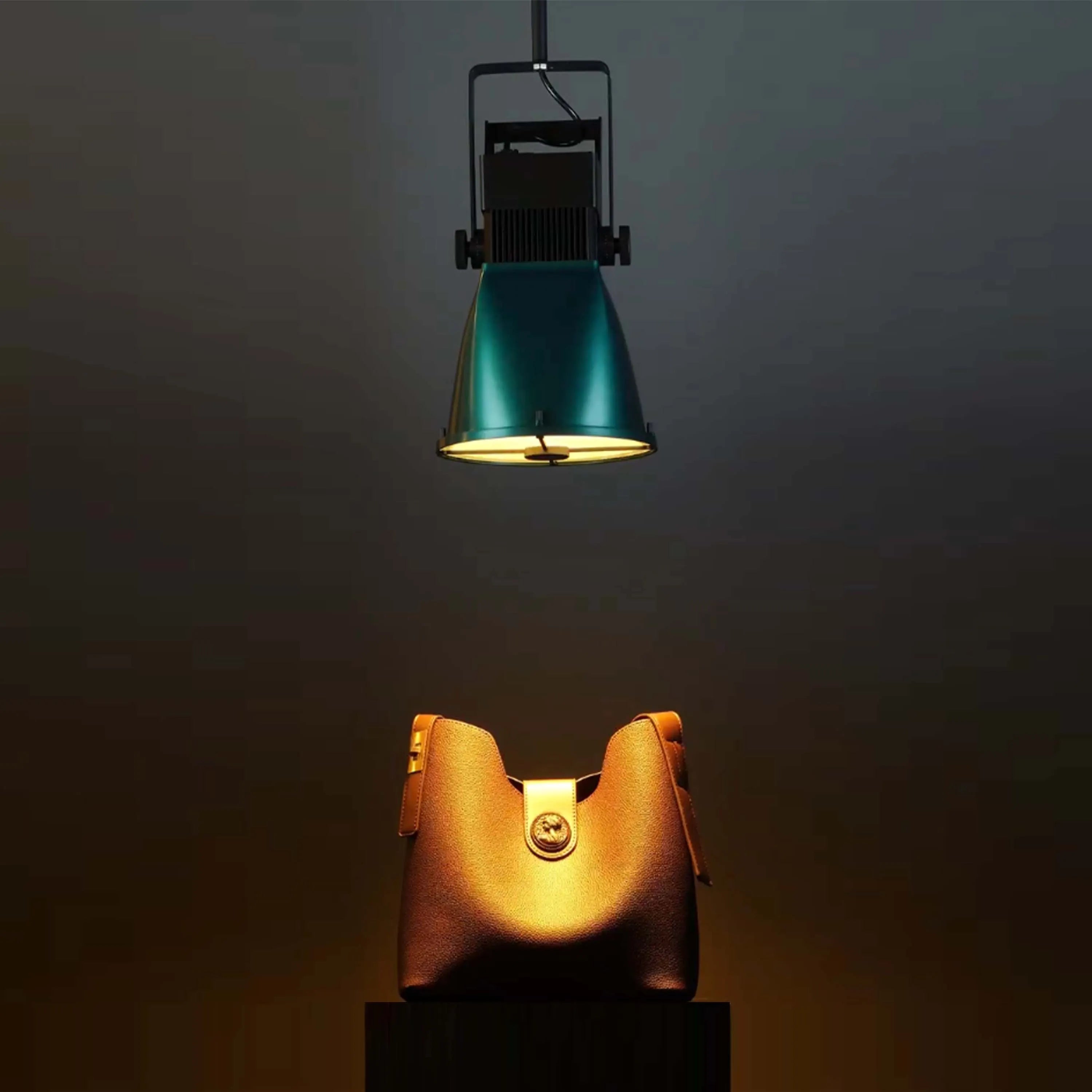 Studio lighting showcasing a leather handbag. The single spotlight creates a dramatic, focused effect.