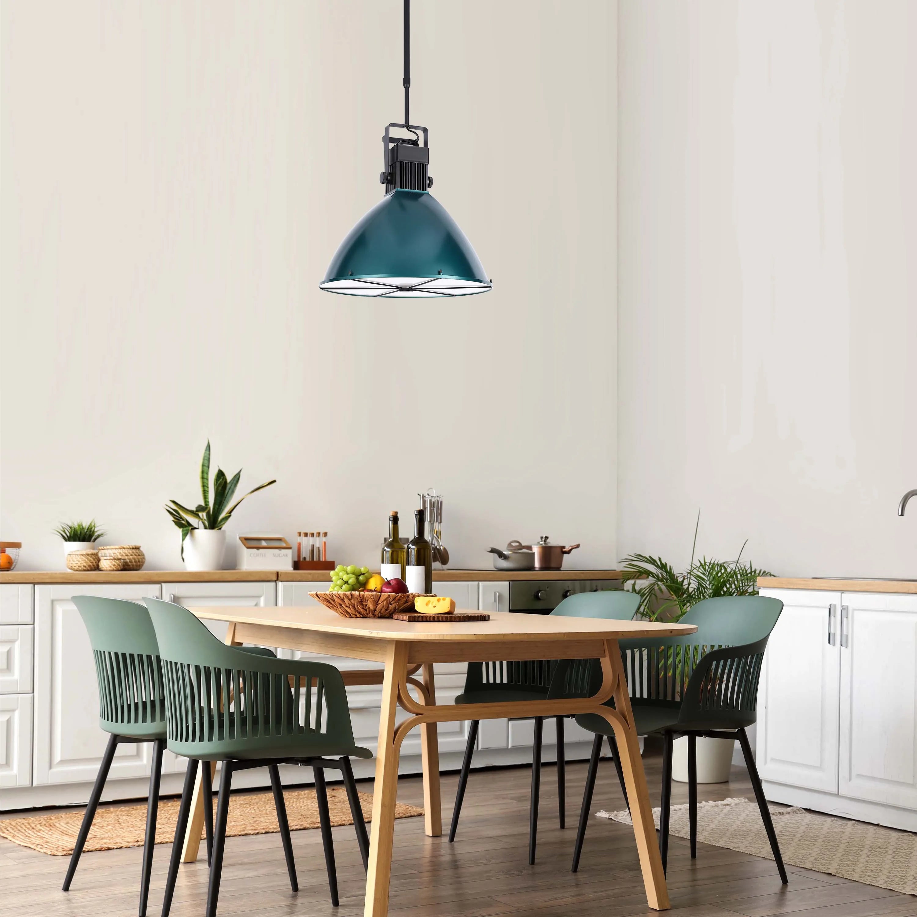 An industrial-style teal pendant lamp provides ambient lighting over a dining table with contemporary green chairs.