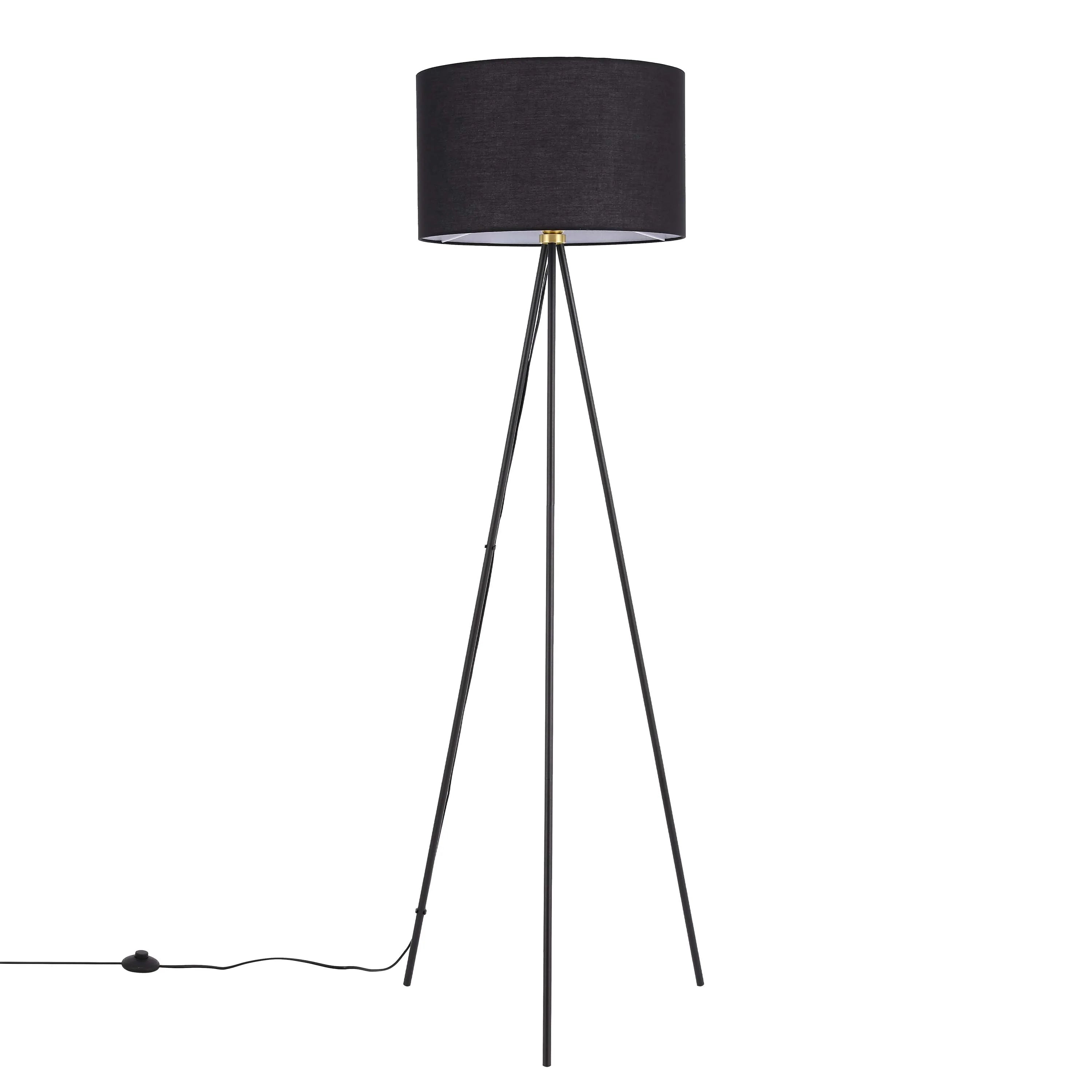 A stylish tripod floor lamp with a black fabric shade. Its sleek design complements any modern interior.